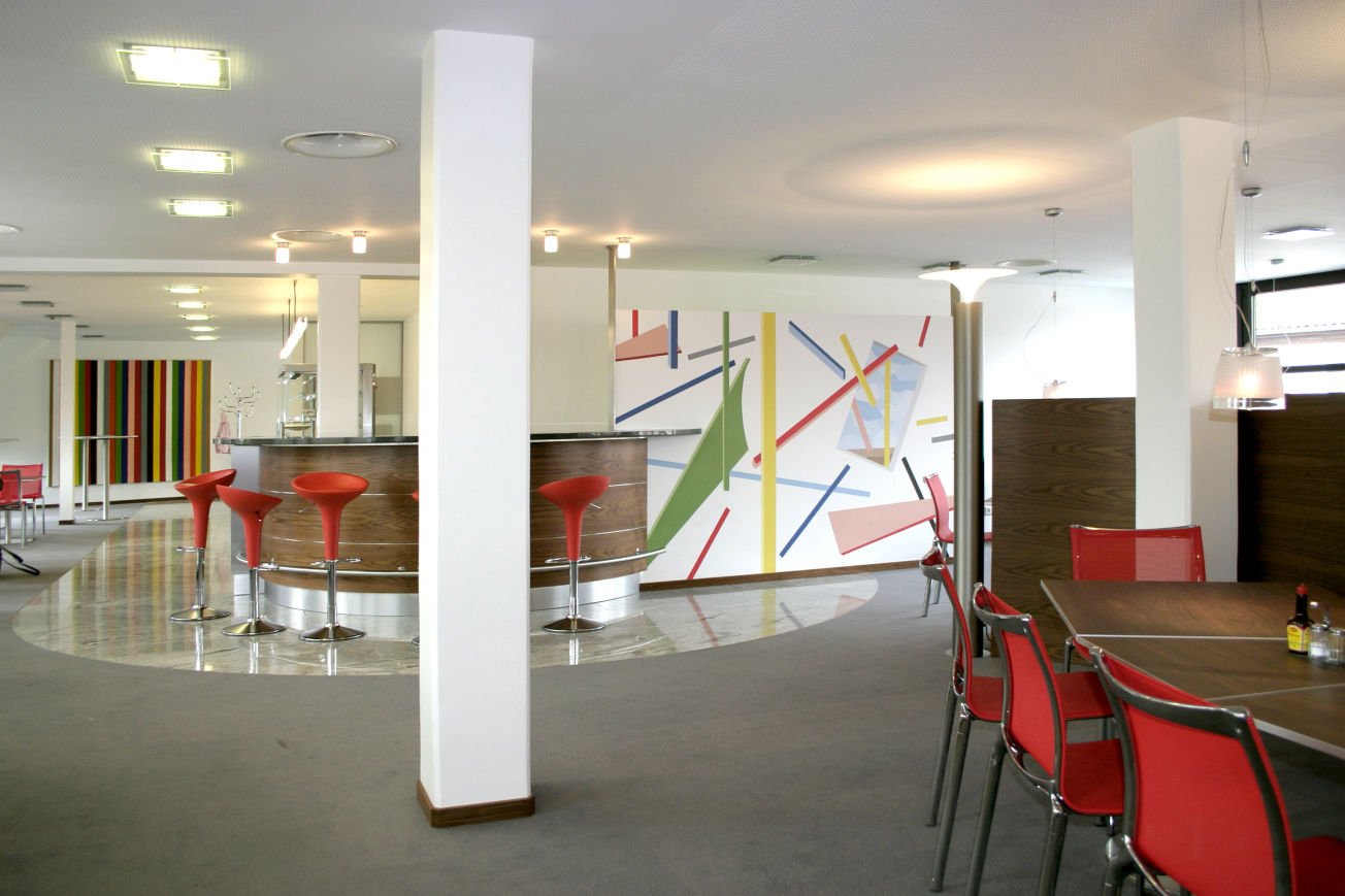 Wandmalerei und Illusionsmalerei ist in nahezu jedem Unternehmen und überall einsetzbar. Ob in Büros, Foyers, Fluren oder wie auf diesem Foto in einer Kantine - kleine und große Wandflächen können gezielt genutzt werden, künstlerisch die jeweilige Botschaft des Unternehmens zu darzustellen.
