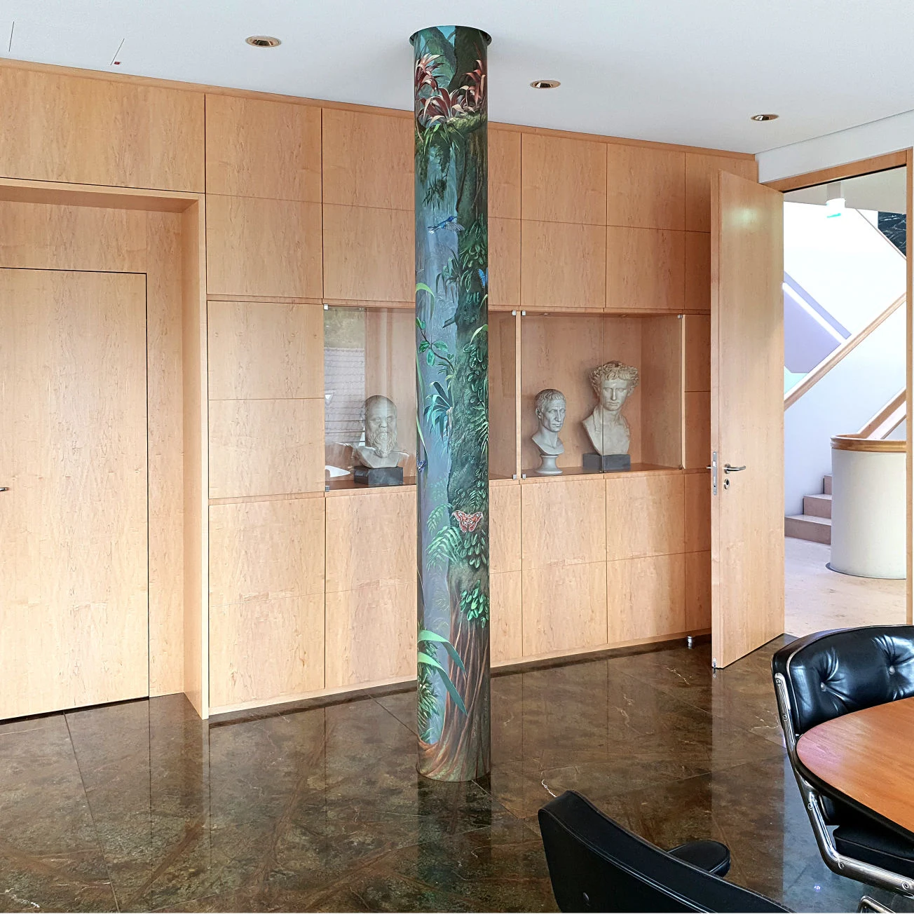 Wandmalerei und Illusionsmalerei eignet sich auch für runde Formen, wie Säulen. Der Künstler Uwe Fehrmann gestaltete für das Unternehmen Q1 Energie AG dieses Büro mit Dschungel-Motiven.
